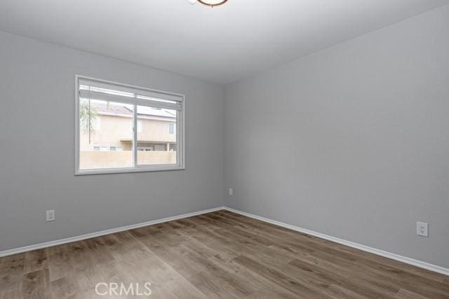 empty room with baseboards and wood finished floors