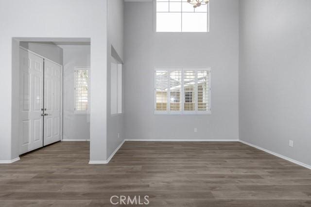 foyer featuring a chandelier, baseboards, and wood finished floors