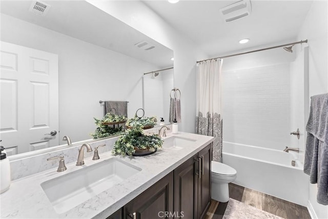 bathroom featuring wood finished floors, visible vents, and a sink
