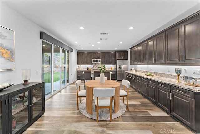 dining room featuring wood finished floors, visible vents, and recessed lighting