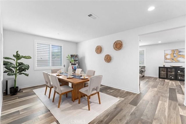 dining space with recessed lighting, wood finished floors, a healthy amount of sunlight, and baseboards