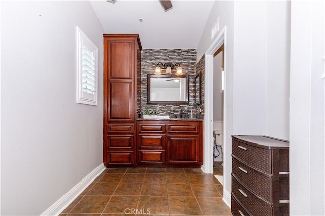 corridor featuring dark tile patterned flooring and baseboards