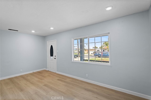 entrance foyer with light wood-style floors, baseboards, visible vents, and recessed lighting
