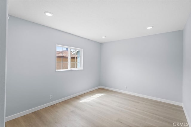 spare room with light wood-style flooring, baseboards, and recessed lighting