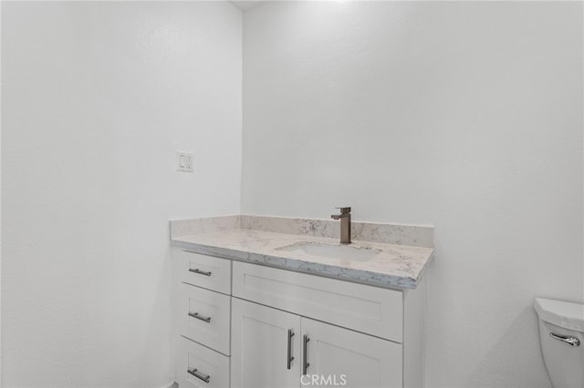 half bathroom featuring toilet and vanity