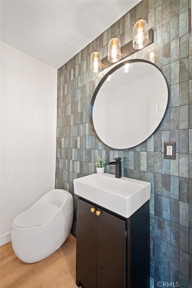 bathroom featuring vanity, tile walls, and wood finished floors
