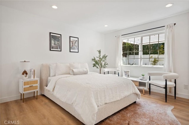 bedroom with recessed lighting, wood finished floors, and baseboards