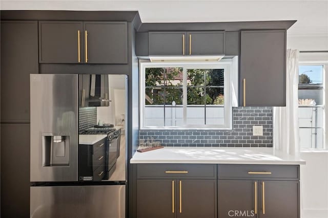 kitchen with ornamental molding, stainless steel refrigerator with ice dispenser, tasteful backsplash, gas stove, and light countertops