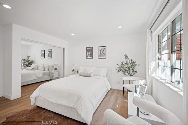 bedroom featuring recessed lighting, a closet, baseboards, and light wood-style flooring