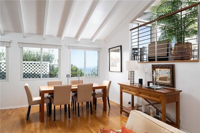 dining room featuring baseboards, lofted ceiling with beams, and wood finished floors
