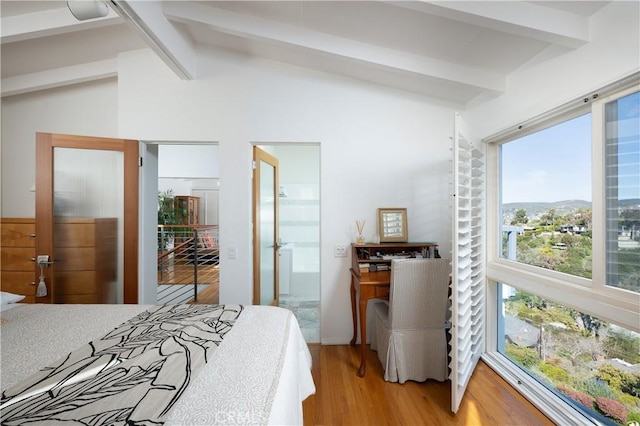 bedroom featuring vaulted ceiling with beams and light wood finished floors