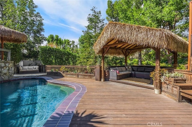 view of pool with an outdoor living space and a wooden deck