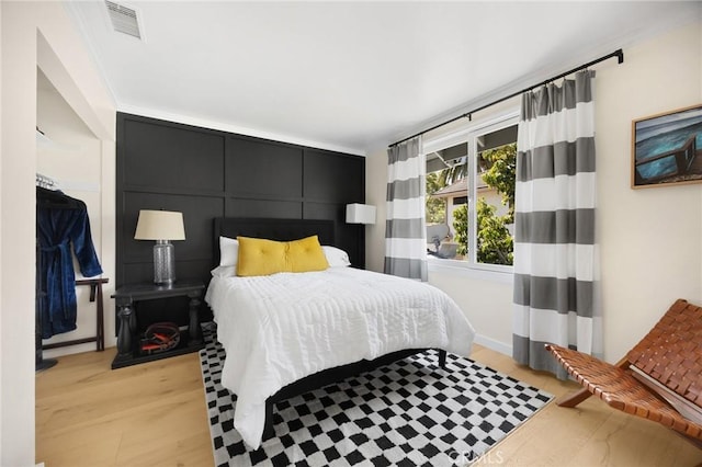 bedroom with light wood finished floors and visible vents