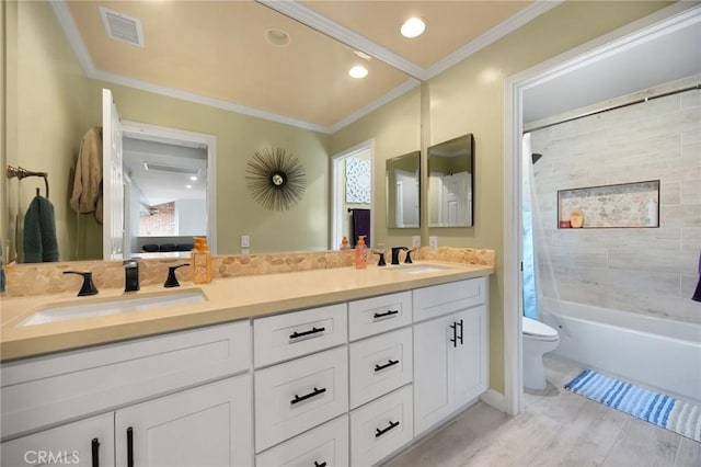 bathroom featuring toilet, double vanity, a sink, and visible vents