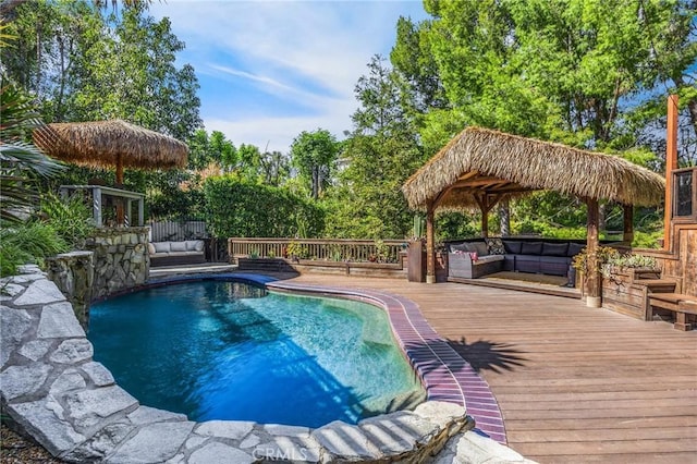 pool with outdoor lounge area and a wooden deck