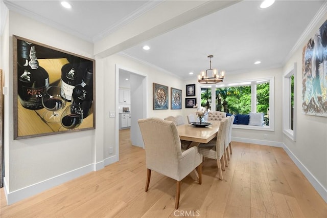dining room featuring crown molding, baseboards, and light wood finished floors