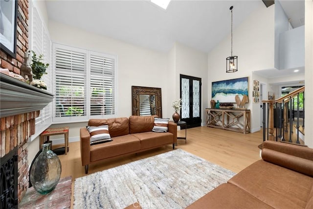 living room featuring a notable chandelier, baseboards, stairway, high vaulted ceiling, and wood finished floors