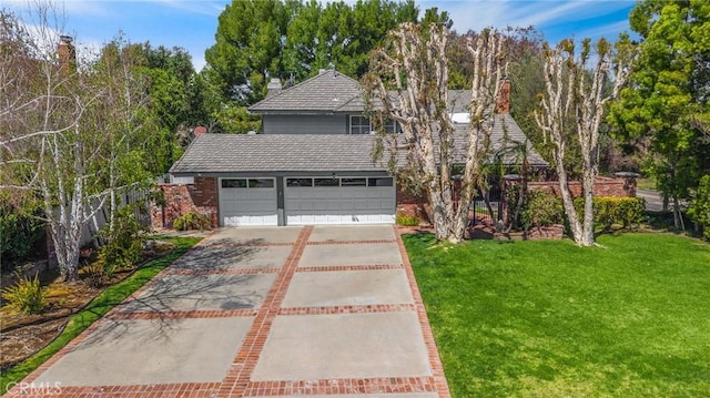 traditional home featuring an attached garage, concrete driveway, and a front yard