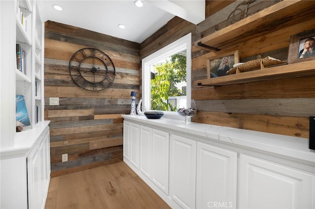washroom with recessed lighting, wooden walls, and light wood-style floors