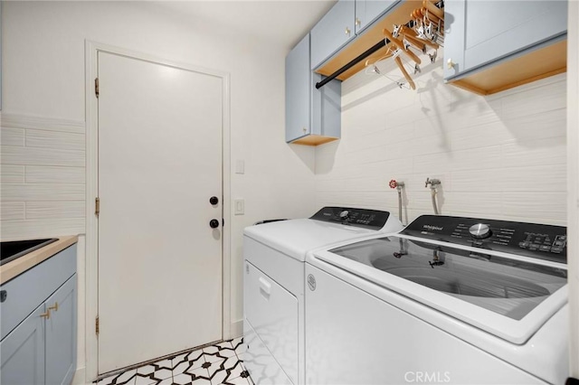 laundry room with separate washer and dryer and cabinet space