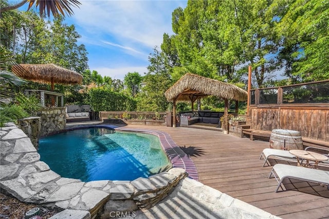 view of pool featuring an outdoor living space, a wooden deck, and a fenced in pool