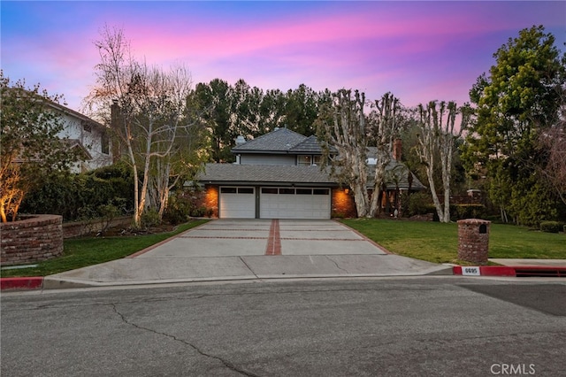 traditional-style home with concrete driveway, brick siding, a garage, and a lawn