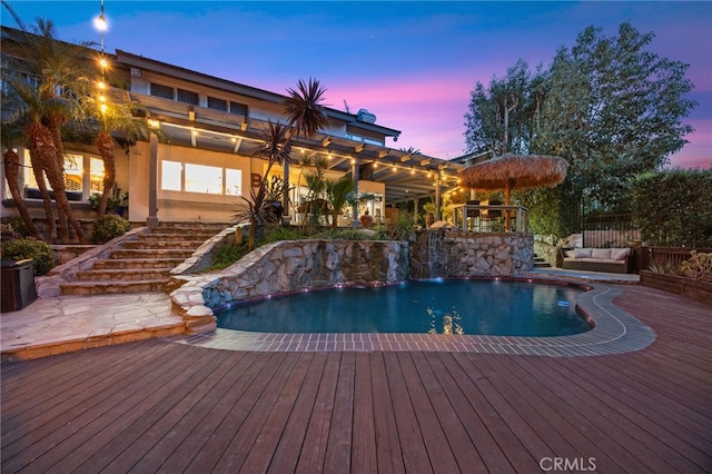 outdoor pool featuring central AC unit, an outdoor hangout area, a wooden deck, and stairs
