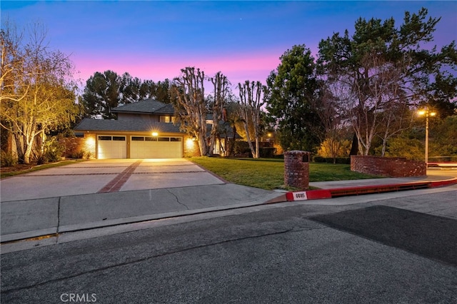traditional home with driveway and a lawn