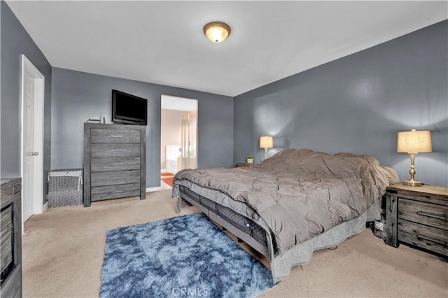 carpeted bedroom with connected bathroom and baseboards