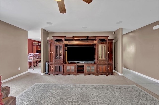 living room with ceiling fan, light carpet, and baseboards