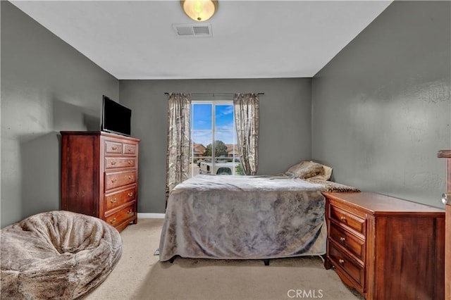bedroom with visible vents, light carpet, and baseboards