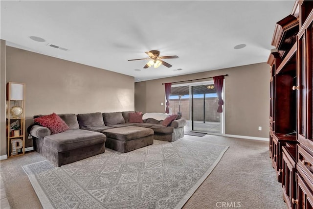 living area with carpet flooring, visible vents, ceiling fan, and baseboards
