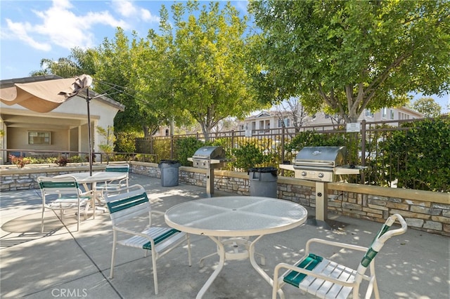 view of patio with area for grilling, an outdoor kitchen, fence, and outdoor dining space
