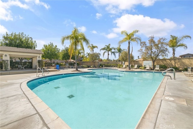 community pool featuring a patio area and fence
