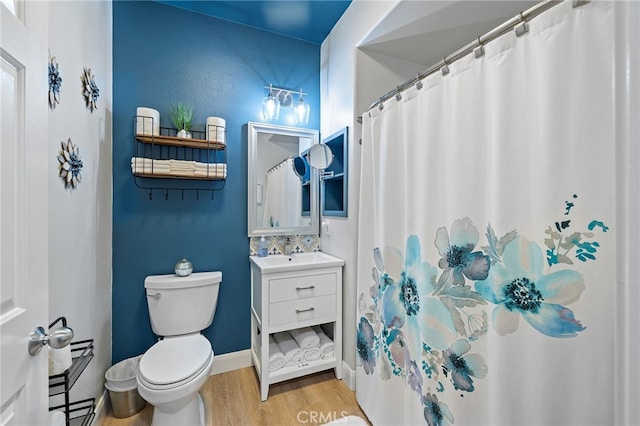 bathroom featuring toilet, wood finished floors, and vanity