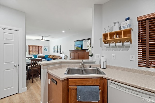 kitchen with a ceiling fan, light wood-type flooring, light countertops, a sink, and dishwasher