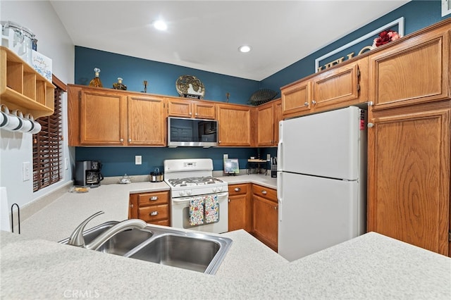 kitchen featuring white appliances, brown cabinets, a sink, and light countertops