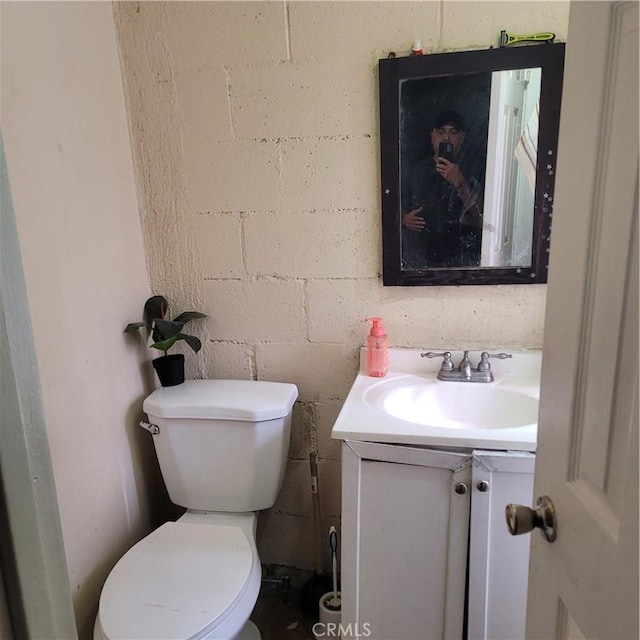 125 W Vernon Ave, Los Angeles, CA 90037 - bathroom with concrete block wall, toilet, and vanity