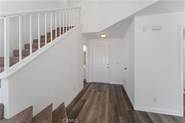 interior space with wood finished floors, baseboards, and stairway