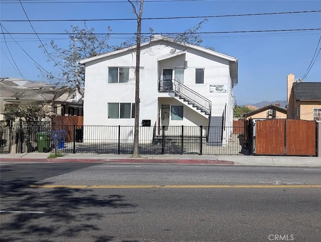 12929 Van Nuys Blvd, Pacoima, CA 91331 - view of front of house featuring stucco siding, a fenced front yard, and stairway