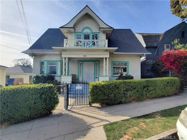 717-723 E Kensington Rd, Los Angeles, CA 90026 - view of front of house featuring a gate, a balcony, a fenced front yard, covered porch, and roof with shingles