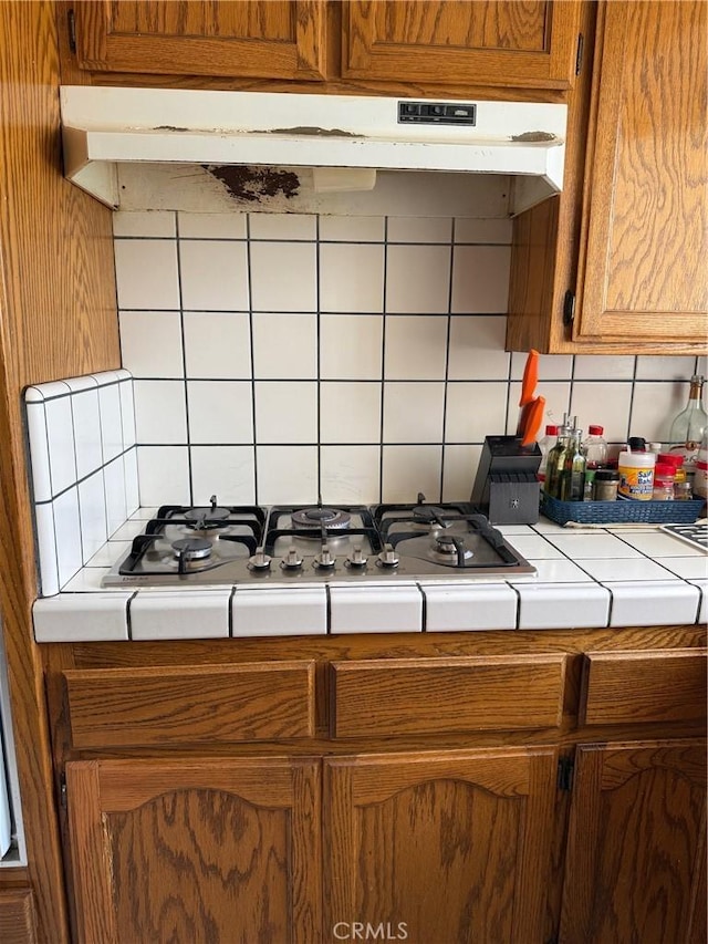 3816 Phaffle Dr, Bakersfield, CA 93309 - kitchen featuring tile counters, tasteful backsplash, under cabinet range hood, and stainless steel gas stovetop
