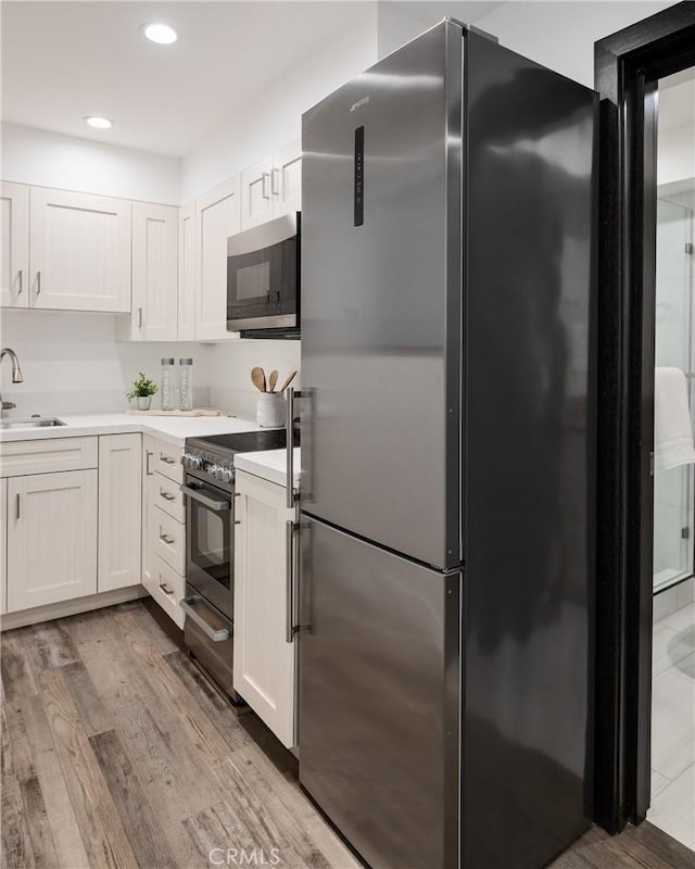 201 S Juanita Ave, Redondo Beach, CA 90277 - kitchen with stainless steel appliances, light countertops, wood finished floors, white cabinetry, and recessed lighting