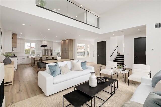 201 S Juanita Ave, Redondo Beach, CA 90277 - living area featuring recessed lighting, stairs, light wood-type flooring, and a towering ceiling
