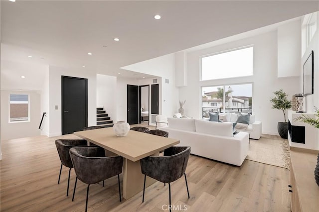 201 S Juanita Ave, Redondo Beach, CA 90277 - dining area featuring stairs, light wood-style flooring, healthy amount of natural light, recessed lighting, and a towering ceiling