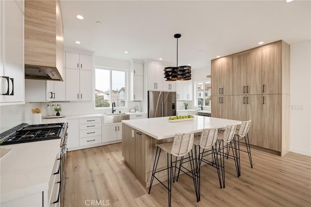 201 S Juanita Ave, Redondo Beach, CA 90277 - kitchen with stainless steel fridge with ice dispenser, wall chimney exhaust hood, light wood finished floors, a kitchen bar, and recessed lighting