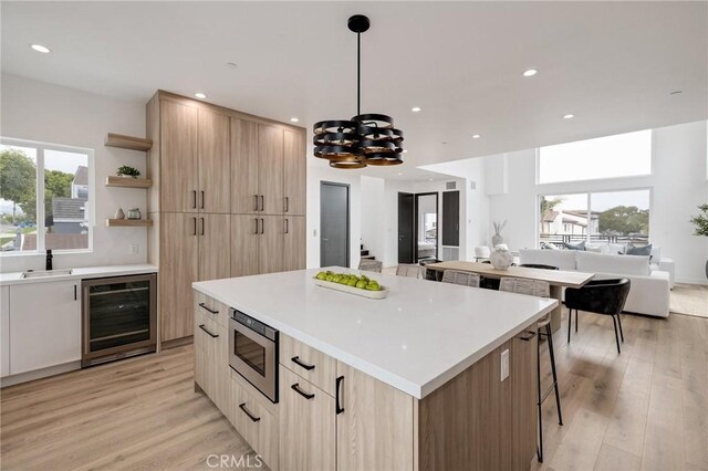 201 S Juanita Ave, Redondo Beach, CA 90277 - kitchen featuring beverage cooler, stainless steel microwave, light brown cabinetry, open shelves, and modern cabinets