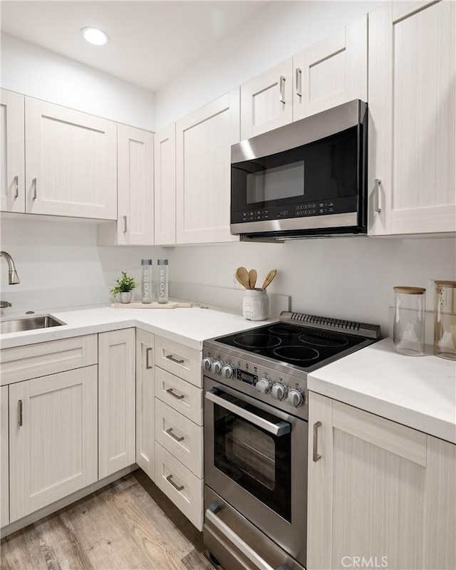201 S Juanita Ave, Redondo Beach, CA 90277 - kitchen with appliances with stainless steel finishes, light wood finished floors, light countertops, recessed lighting, and white cabinetry