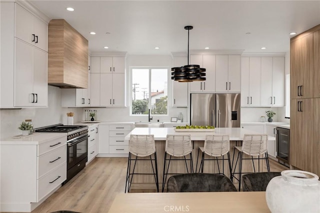 201 S Juanita Ave, Redondo Beach, CA 90277 - kitchen with stainless steel fridge, high end black range, a kitchen breakfast bar, light wood-style floors, and a kitchen island