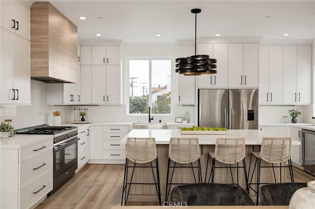 201 S Juanita Ave, Redondo Beach, CA 90277 - kitchen featuring stainless steel fridge, range with two ovens, wall chimney exhaust hood, a breakfast bar area, and recessed lighting